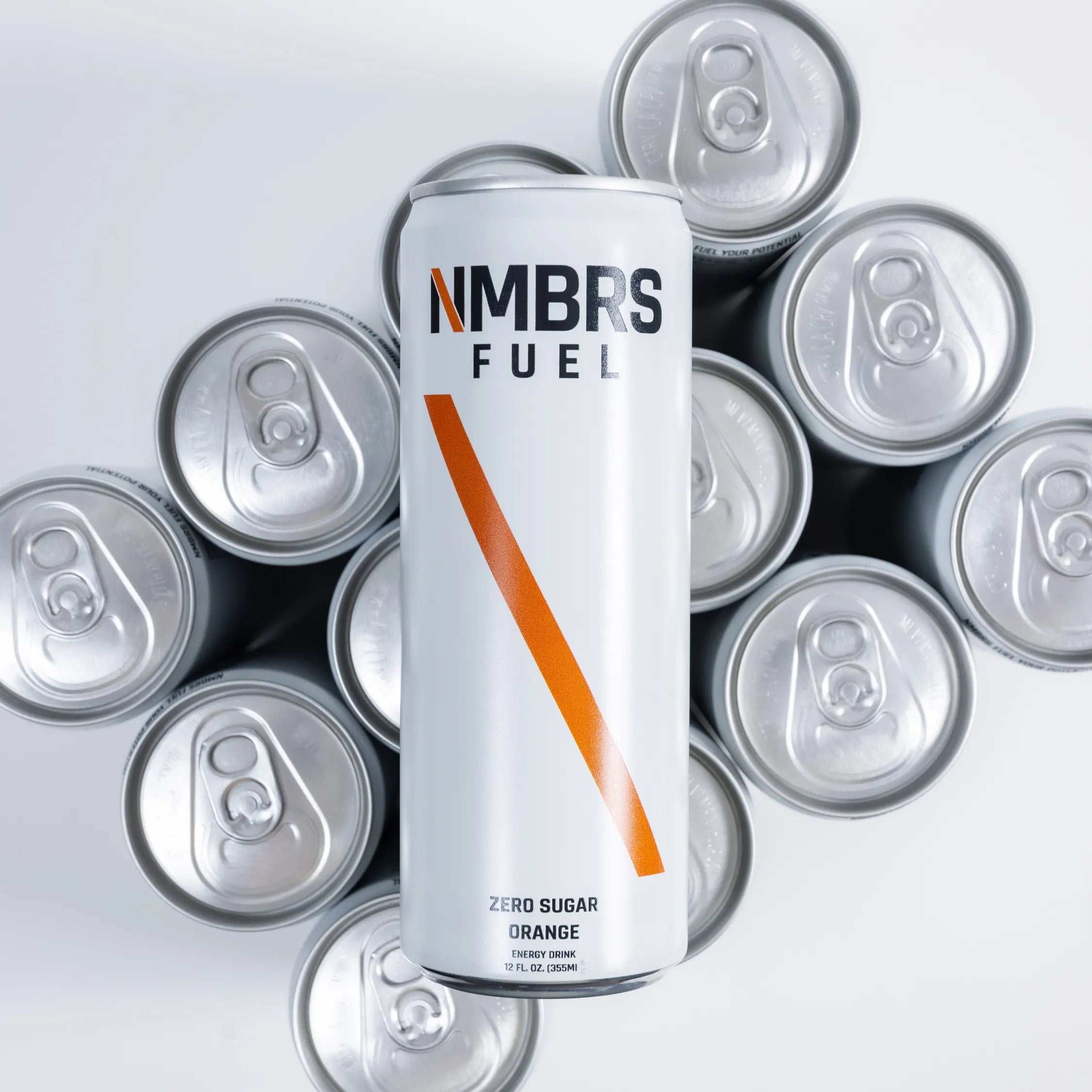 NIMBRS FUEL energy drink can surrounded by silver cans on a light gray background