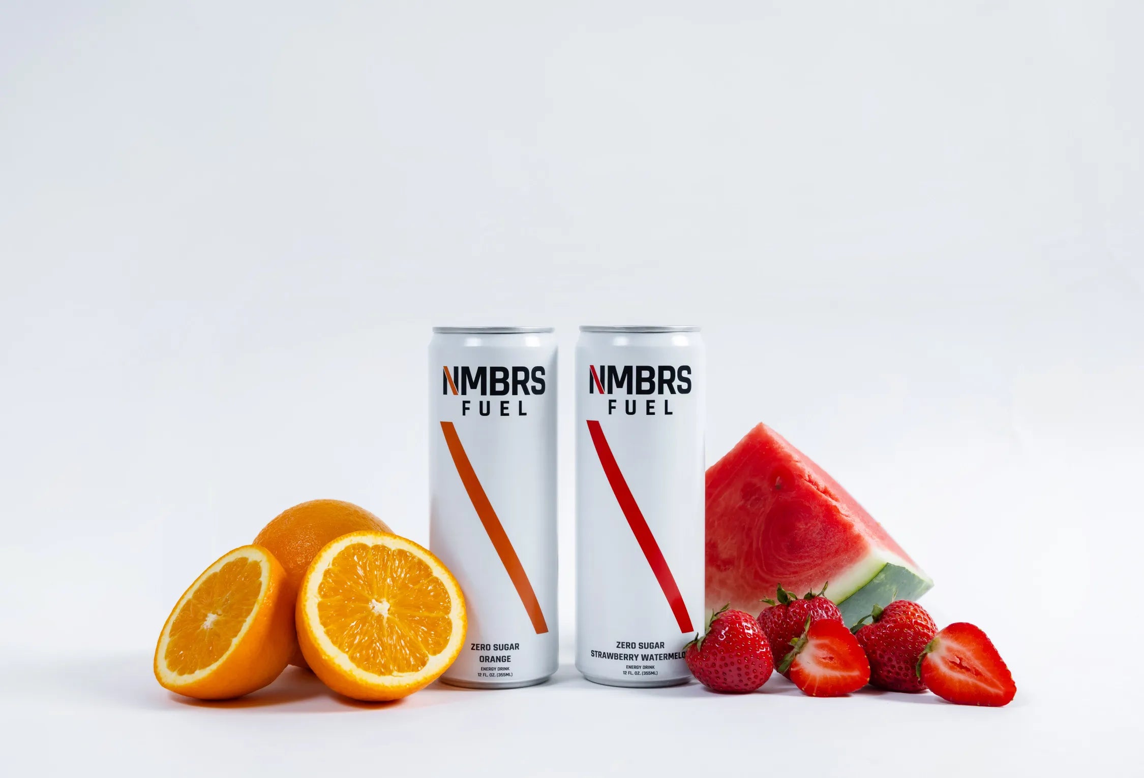 Two cans of NMBS Fuel with fruits on a white background