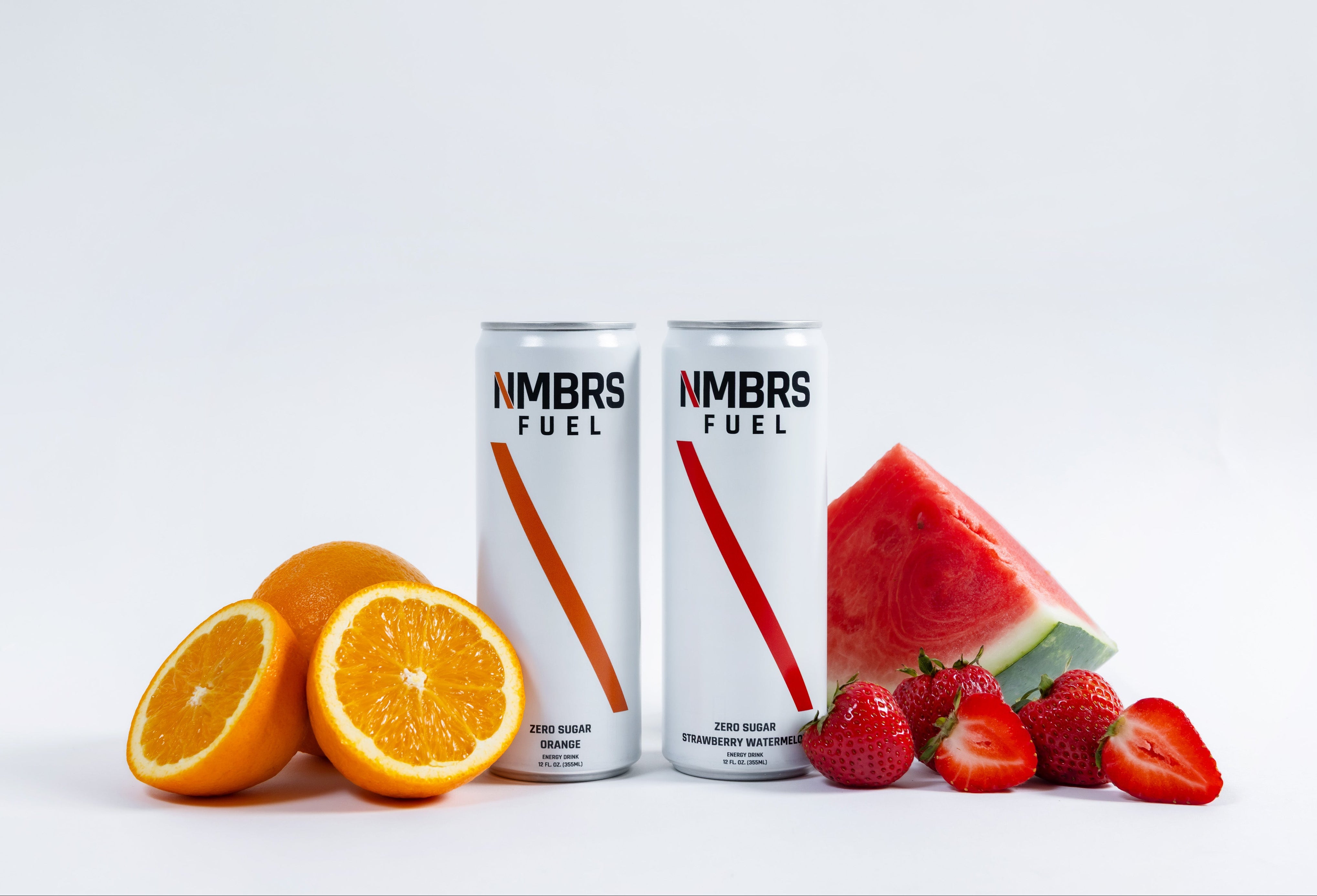 Two cans of NMBS Fuel with fruits on a white background